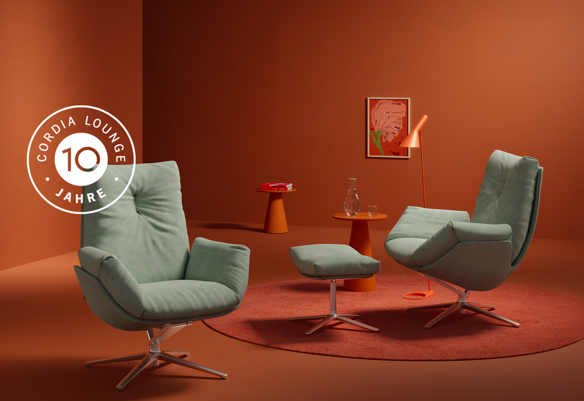 Zwei moderne Loungesessel in orangefarbenem Raum