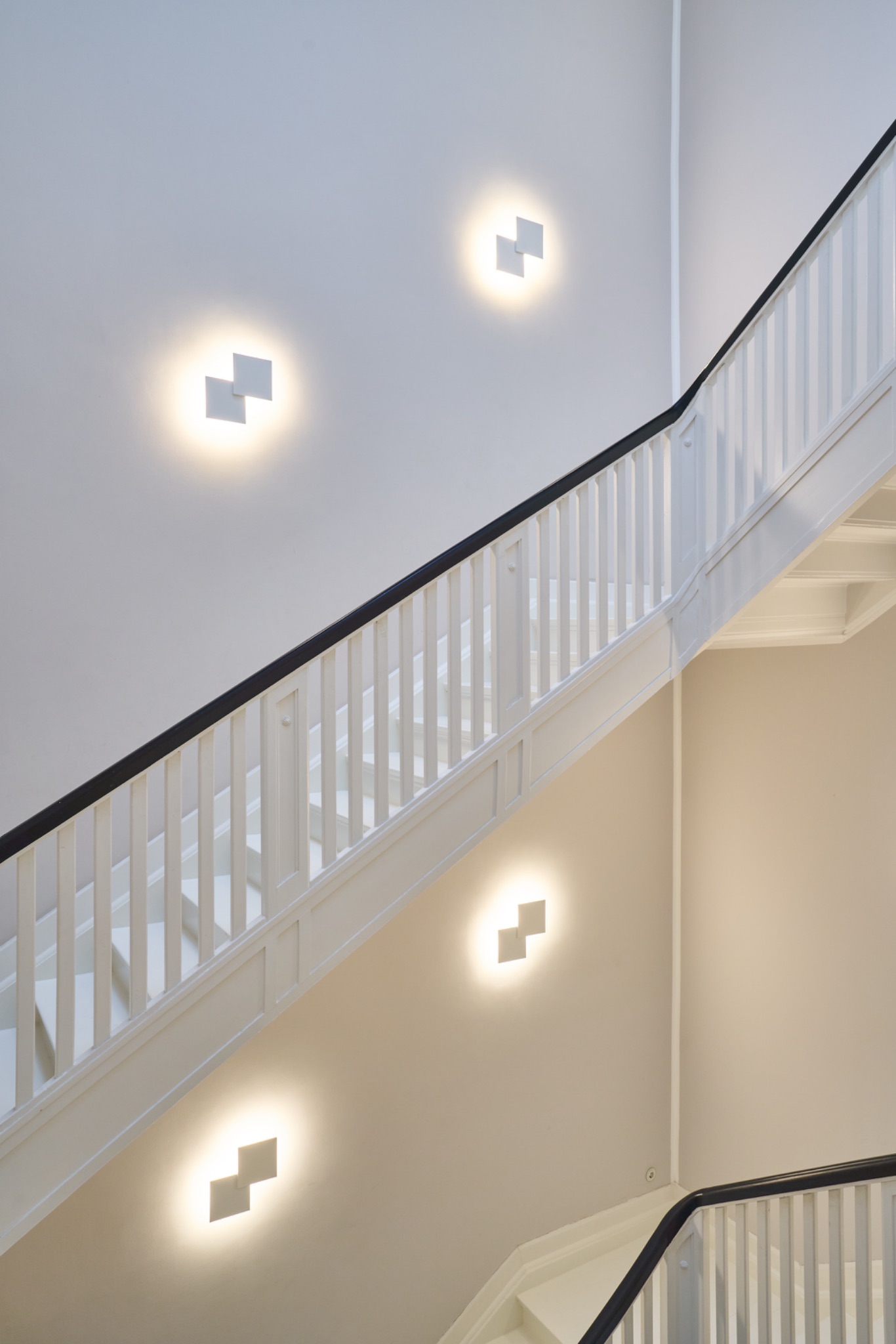 Moderne weiße Treppe mit Wandlampen